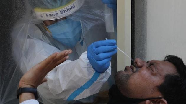 A health worker takes a nasal swab sample to test for Covid-19 in New Delhi on Saturday.(AP Photo)