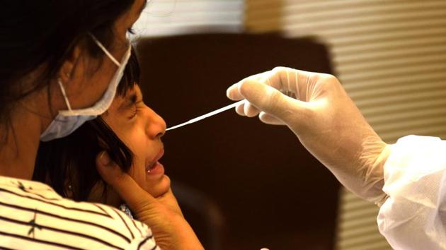 A BMC health care worker collect swab sample of a resident at Bandra during Covid-19 pandemic in Mumbai on Saturday. (Satish Bate/HT Photo) A BMC health care worker collect swab sample of a resident at Bandra during Covid-19 pandemic in Mumbai on Saturday. (Satish Bate/HT Photo)