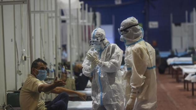 A Covid-19 patient talks to health workers wearing PPE kits inside a ward at the Commonwealth Games (CWG) Village Covid-19 care centre, near Pandav Nagar in New Delhi on Sunday.(Biplov Bhuyan/HT PHOTO) A Covid-19 patient talks to health workers wearing PPE kits inside a ward at the Commonwealth Games (CWG) Village Covid-19 care centre, near Pandav Nagar in New Delhi on Sunday.(Biplov Bhuyan/HT PHOTO)