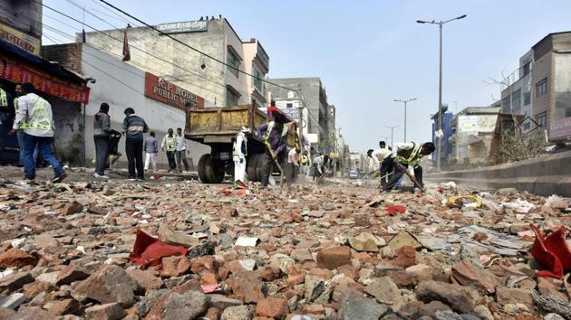 MCD workers clean debris from the road following violent clashes in North East Delhi over the new citizenship law, at Chand Bagh.(Sonu Mehta/HT Photo)