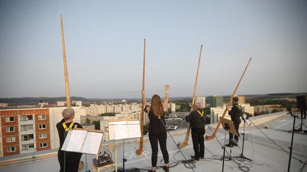 Musicians with alp horns performing on the roof of an apartment block.(AP)