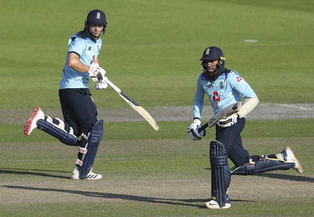 England's Adil Rashid, right, and Tom Curran run between the wickets to score during the second ODI cricket match between England and Australia, at Old Trafford in Manchester, England, Sunday, Sept. 13, 2020. (Martin Rickett/Pool via AP) (AP)