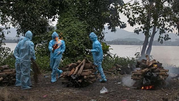 People wearing PPE coveralls perform rituals for the cremation of a relative who died of coronavirus (COVID-19) disease in Guwahati on September 10. India, on average, has been reporting at least 1,000 new deaths daily due to Covid-19 for the past three weeks now. (Anupam Nath / AP)