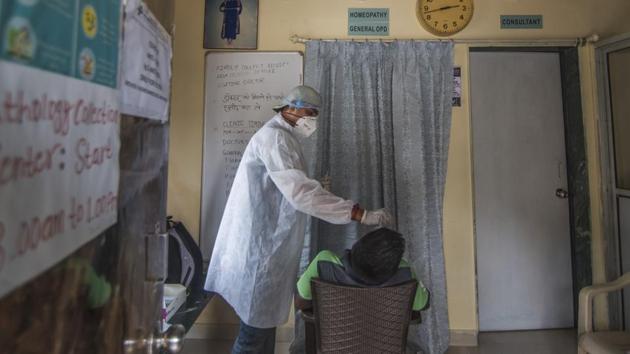 Healthcare worker collects swab sample of the residents while Covid-19 checkup camp at Laxmi Colony,Vashi Naka in Mumbai (Photo by Pratik Chorge/Hindustan Times)