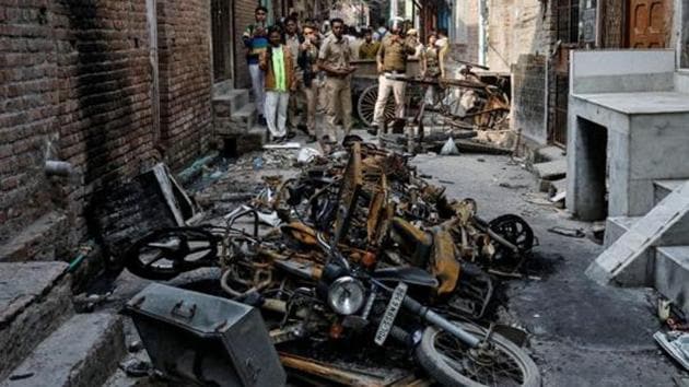 Police photograph burnt out properties owned by Muslims in a riot affected area following clashes between people demonstrating for and against the CAA.(Reuters image)