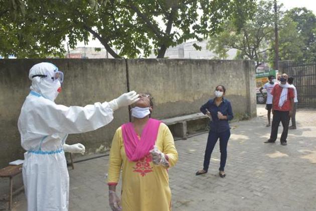 A health worker collects a swab sample for coronavirus disease testing from an individual, at Vijay Nagar, in Ghaziabad(Sakib Ali /HT Photo)