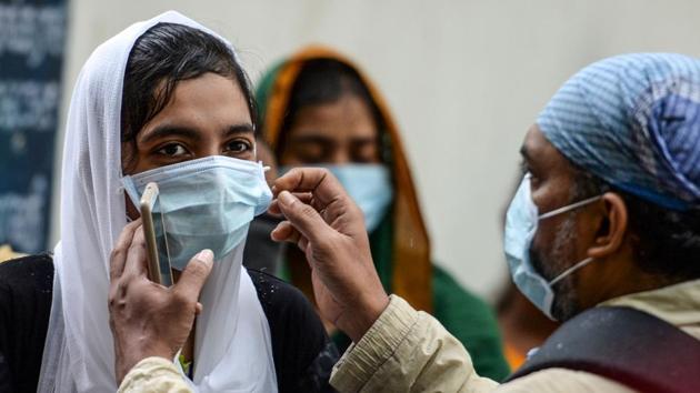 A man adjusts his daughter’s facemask outside an examination centre in Chennai on September 13. Analysing the spread of the Covid-19 in the country the health ministry also shared that sixty percent of the active cases are concentrated in Maharashtra, Karnataka, Andhra Pradesh, Uttar Pradesh and Tamil Nadu after lockdown restrictions were eased throughout the country. (Arun Sankar / AFP) A man adjusts his daughter’s facemask outside an examination centre in Chennai on September 13. Analysing the spread of the Covid-19 in the country the health ministry also shared that sixty percent of the active cases are concentrated in Maharashtra, Karnataka, Andhra Pradesh, Uttar Pradesh and Tamil Nadu after lockdown restrictions were eased throughout the country. (Arun Sankar / AFP)