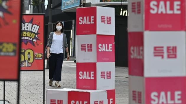 A woman walks past sale signs at the Myeongdong shopping district in Seoul. Covid--ravaged economies across the Asia Pacific are expected to contract this year for the first time in nearly six decades.(AFP)