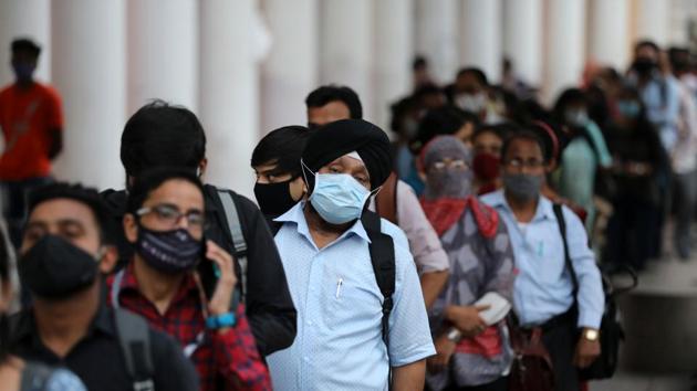 People wearing face masks stand in a line to enter a metro station during Covid-19, in New Delhi on Monday.(Reuters Photo)