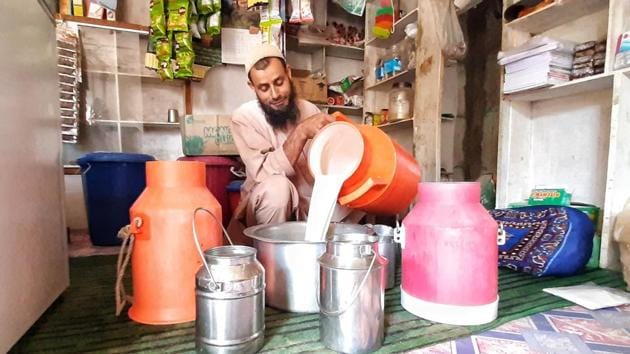 A vendor collecting milk from local households at Bundzoo village, 4km from Pulwama, on Wednesday morning.(Waseem Andrabi/HT)