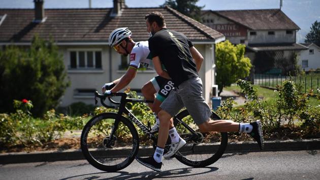 Team Bora rider Slovakia's Peter Sagan is pushed by a staff member after a technical problem during Stage 17 of Tour de France cycling race between Grenoble and Meribel in France on September 16. According to AFP’s report the two strongest teams Ineos and Jumbo are back as favourites again this year. (Anne-Christine Poujoulat / AFP)