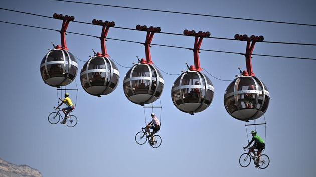 Cyclists hang under the Grenoble Bastille cable cars during the 107th edition of Tour de France cycling race, between Grenoble and Meribel in France, on September 16. This year amid coronavirus concerns, the race has been postponed from July, which is for the first time since World War II . (Anne-Christine Poujoulat / AFP)