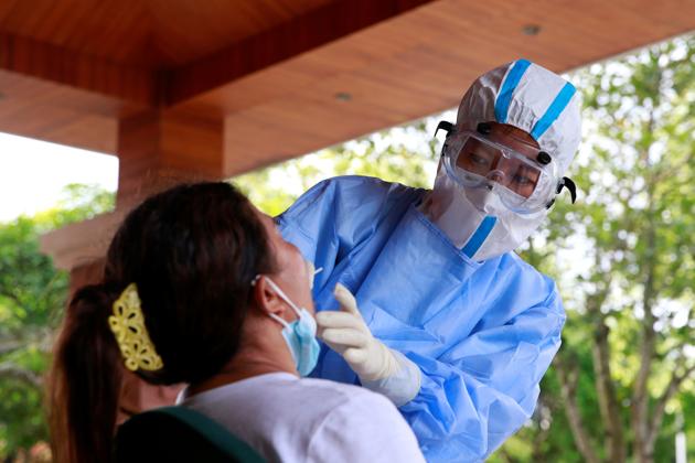 A medical worker in protective suit collects a swab sample from a woman for nucleic acid testing following two imported coronavirus disease (COVID-19) infections from neighbouring Myanmar, at a hotel in the border city of Ruili, Dehong prefecture, Yunnan province, China September 15, 2020. Picture taken September 15, 2020.(REUTERS)