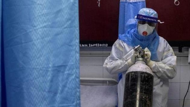 File photo: A medical worker wearing personal protective equipment (PPE) pushes an oxygen cylinder for a patient suffering from the coronavirus disease (COVID-19). (REUTERS)