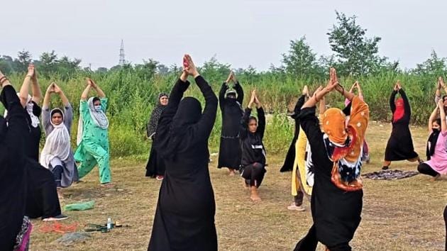 Women, many of them in burqa, practicing yoga in Haldwani town of Nainital district in Uttarakhand.(HT Photo)