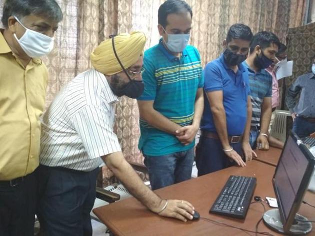Panjab University controller of examinations, Parvinder Singh, with technical staff overseeing arrangements for the smooth conduct of the online exams at the control room on Thursday.(HT Photo)