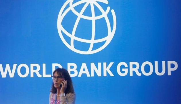 FILE PHOTO: A participant stands near a logo of World Bank at the International Monetary Fund - World Bank Annual Meeting 2018 (REUTERS/Johannes P. Christo)