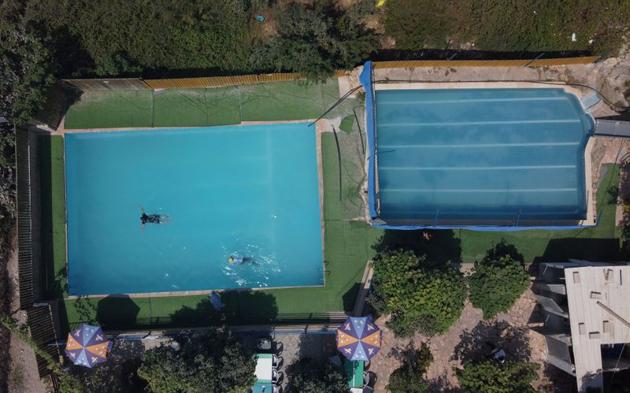Malak Hasan and Bisan Alhajhasan swim in a pool in the village of Aboud near Ramallah in the Israeli-occupied West Bank September 15, 2020. (REUTERS)