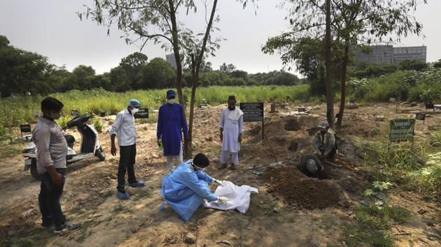 A man wearing PPE coveralls prepares for the burial of his three month old son who died of Covid-19 in New Delhi on September 16. 1,132 new fatalities were reported on September 17 morning taking the Covid-19 death toll in India to 83,198. (Manish Swarup / AP) A man wearing PPE coveralls prepares for the burial of his three month old son who died of Covid-19 in New Delhi on September 16. 1,132 new fatalities were reported on September 17 morning taking the Covid-19 death toll in India to 83,198. (Manish Swarup / AP)