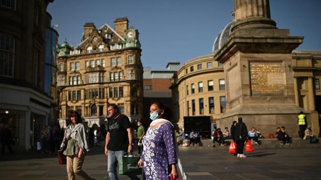 Pedestrians and shoppers, some wearing a face mask or coverings due to Covid-19, walk in Newcastle city centre, north-east England, on September 17.(AFP)