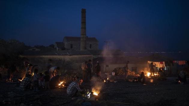 Migrants sit around a bonfire as others gather near a road leading from Moria to the capital of Mytilene on the island of Lesbos on September 17. According to AP, Moria had a capacity of just over 2,700 people, but more than 12,500 people had been living in and around it when it burned down. The camp and its squalid conditions were held up by critics as a symbol of Europe’s failed migration policies. (Petros Giannakouris / AP) Migrants sit around a bonfire as others gather near a road leading from Moria to the capital of Mytilene on the island of Lesbos on September 17. According to AP, Moria had a capacity of just over 2,700 people, but more than 12,500 people had been living in and around it when it burned down. The camp and its squalid conditions were held up by critics as a symbol of Europe’s failed migration policies. (Petros Giannakouris / AP)