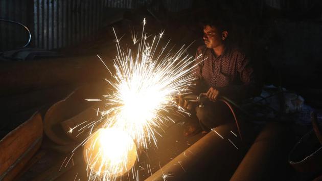 A worker welds an iron pipe at a shop in Mumbai. India’s economy contracted by 23.9% in the April-June quarter, its worst performance in at least 24 years, as the coronavirus pandemic ravaged what was once the world's fastest growing major economy.(AP)