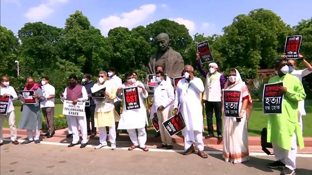 Opposition MPs hold placards as they protest demanding to clear the GST dues to states, in front of Mahatma Gandhi Statue at Parliament during the Monsoon Session, in New Delhi on September 17, 2020.(ANI Photo)
