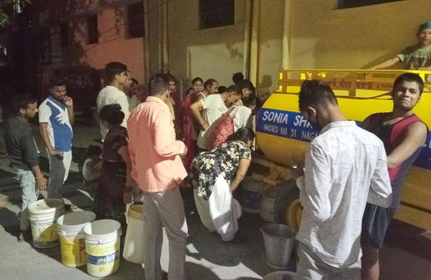 Residents queuing up to collect water from a tanker at Ward number 31 in Ludhiana on Saturday.(HT Photo)