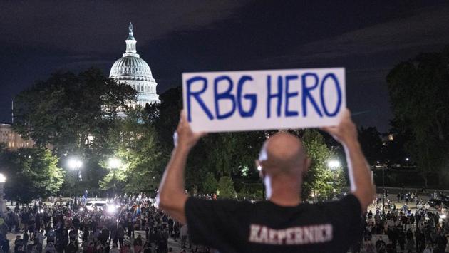 A person holds a sign reading “RBG HERO” as mourners gather during a vigil for Ruth Bader Ginsburg outside of the Supreme Court in Washington on September 18. Ginsburg in recent years served as the most senior member of the court liberal wing, consistently delivering progressive votes on the most divisive social issues of the day, including abortion rights, same-sex marriage, voting rights, immigration, health care and affirmative action. (Sarah Silbiger / Bloomberg) 