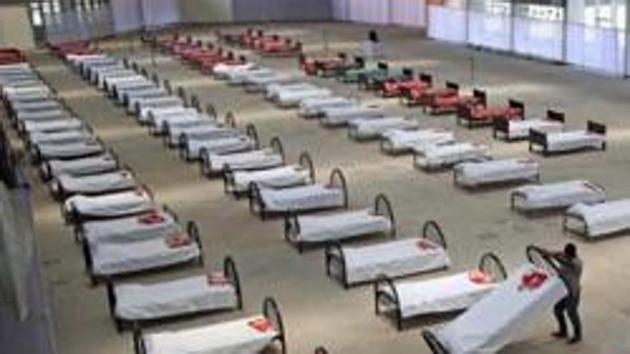 A worker arranges beds at a quarantine centre in an indoor international fair complex in Agartala.(ANI FILE PHOTO)