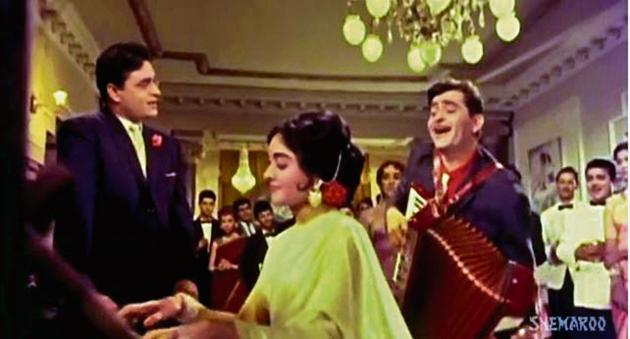 Sangam’s classic love triangle, with Rajendra Kumar, Vyjayanthimala and Raj Kapoor (his accordion ever-present), plays out at a posh party, to Har Dil Jo Pyar Karega. Note that the guests are merely spectators — props for the show within the show. Sangam’s classic love triangle, with Rajendra Kumar, Vyjayanthimala and Raj Kapoor (his accordion ever-present), plays out at a posh party, to Har Dil Jo Pyar Karega. Note that the guests are merely spectators — props for the show within the show.