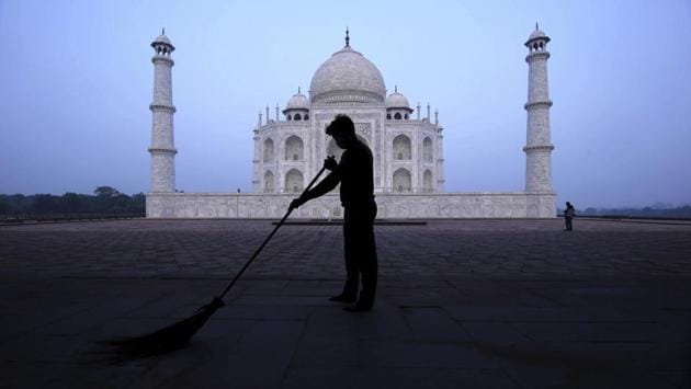 A man sweeps at the Taj Mahal early morning in Agra on September 21. Among 3691 monuments across India under the ASI, many were opened for the public since July 6, except Taj Mahal and Agra fort as both fell in coronavirus containment zones.  (Pawan  Sharma / AP) 