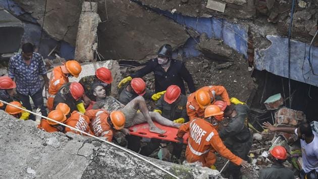 National Disaster Response Force (NDRF) and fire brigade rescue an injured person in Bhiwandi.(PTI)