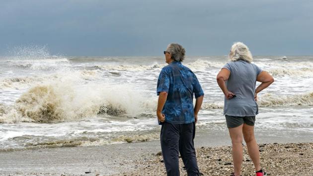 Steve and Linda Buser of Beaumont check out the rough surf on the beach near the intersection of Highway 124 and Highway 87 on the Bolivar Peninsula, Texas.(AP)
