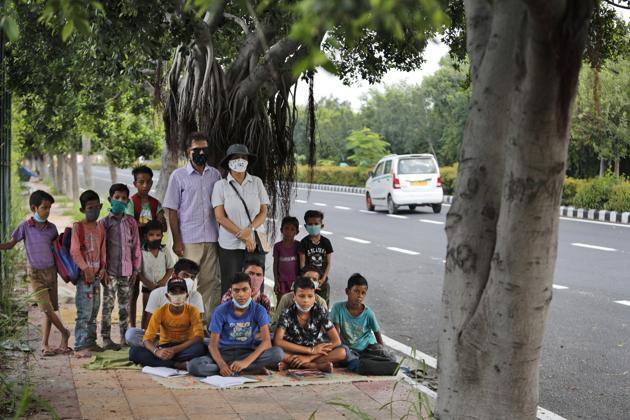 A former diplomat Virendra Gupta and his singer wife Veena Gupta pose for a photograph with underprivileged children whom they teach on a sidewalk in New Delhi, India, on Sept. 3, 2020. The Indian couple are conducting free classes for underprivileged children on a sidewalk in New Delhi with the goal to keep them learning and not left behind when schools reopen. (AP) A former diplomat Virendra Gupta and his singer wife Veena Gupta pose for a photograph with underprivileged children whom they teach on a sidewalk in New Delhi, India, on Sept. 3, 2020. The Indian couple are conducting free classes for underprivileged children on a sidewalk in New Delhi with the goal to keep them learning and not left behind when schools reopen. (AP)
