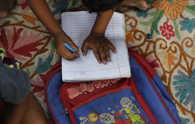 A child practices writing numbers on a sidewalk class in New Delhi, India, on Sept. 3, 2020.\ (AP) A child practices writing numbers on a sidewalk class in New Delhi, India, on Sept. 3, 2020.\ (AP)