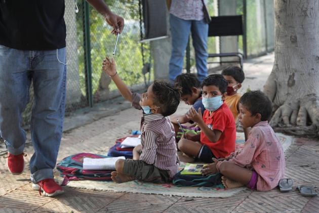 A child takes a pencil during a class conducted by Veena Gupta on a sidewalk in New Delhi, India, Thursday, Sept. 3, 2020. (AP) A child takes a pencil during a class conducted by Veena Gupta on a sidewalk in New Delhi, India, Thursday, Sept. 3, 2020. (AP)