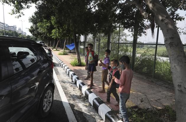 Children wave goodbye to Veena Gupta as she leaves after conducting a class on a sidewalk in New Delhi, India, on Sept. 3, 2020. (AP) Children wave goodbye to Veena Gupta as she leaves after conducting a class on a sidewalk in New Delhi, India, on Sept. 3, 2020. (AP)