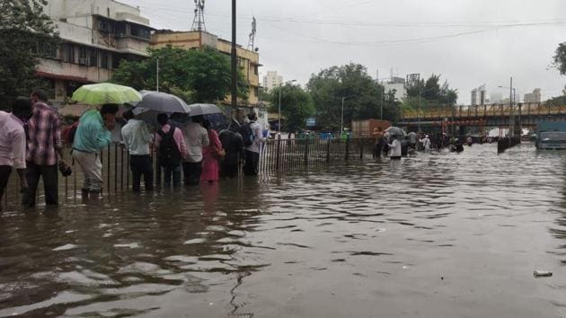 Pedestrians try to reach their destinations amid heavy waterlogging.(Vijayanand Gupta/HT Photos)