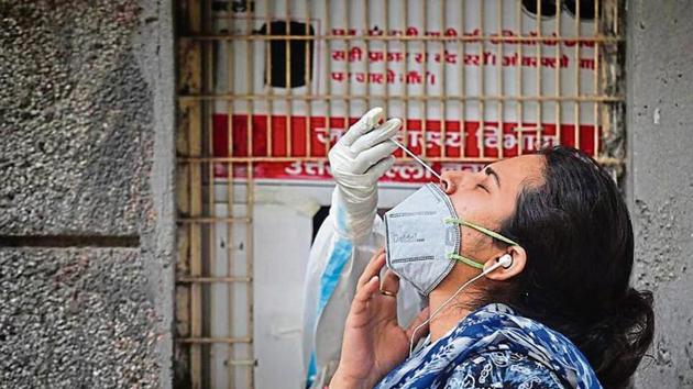 A health worker collects a swab sample at Rajendra Nagar on Wednesday.