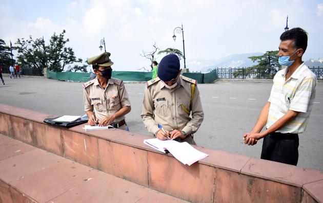 Police challan a man for not wearing facemask properly in Shimla on Wednesday.(Deepak Sansta / HT)