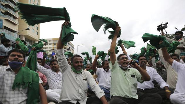 Farmers raise their shawls and shout anti-government slogans to protest farm bills in Bengaluru on September 21. Farmers’ organizations are demanding amendments in the agriculture bills to provide a legal guarantee for minimum support prices (MSP), as they fear that private investments in agricultural sector will dismantle the MSP system. However, the Central government upholds that private investments will boost growth in the farming sector. (Aijaz Rahi / AP) Farmers raise their shawls and shout anti-government slogans to protest farm bills in Bengaluru on September 21. Farmers’ organizations are demanding amendments in the agriculture bills to provide a legal guarantee for minimum support prices (MSP), as they fear that private investments in agricultural sector will dismantle the MSP system. However, the Central government upholds that private investments will boost growth in the farming sector. (Aijaz Rahi / AP)