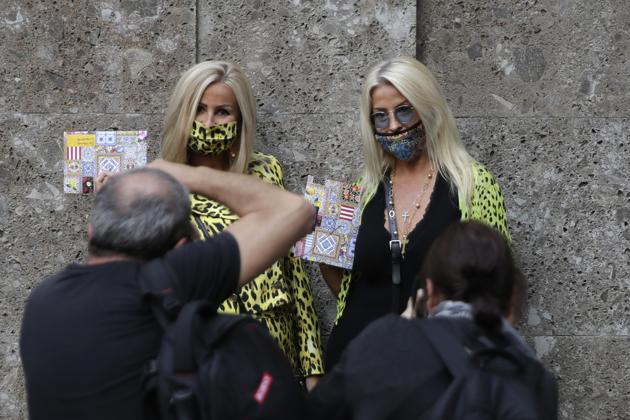 Two guests pose for photographers prior to the Dolce & Gabbana 2021 women's spring-summer ready-to-wear collection during the Milan's fashion week in Milan, Italy, Wednesday, Sept. 23, 2020.  (AP) 