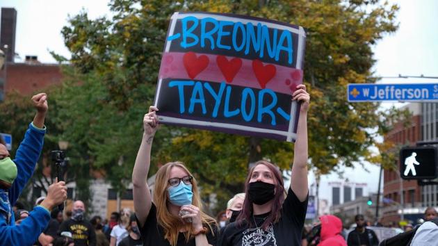 Demonstrators hold a placard while marching in downtown Louisville on September 23. The grand jury in its ruling decided that none of the three white officers involved in the deadly police raid on Taylor’s apartment would be charged for causing her death, though one officer was indicted on charges of endangering her neighbours. (Jeff Dean / AFP) Demonstrators hold a placard while marching in downtown Louisville on September 23. The grand jury in its ruling decided that none of the three white officers involved in the deadly police raid on Taylor’s apartment would be charged for causing her death, though one officer was indicted on charges of endangering her neighbours. (Jeff Dean / AFP)