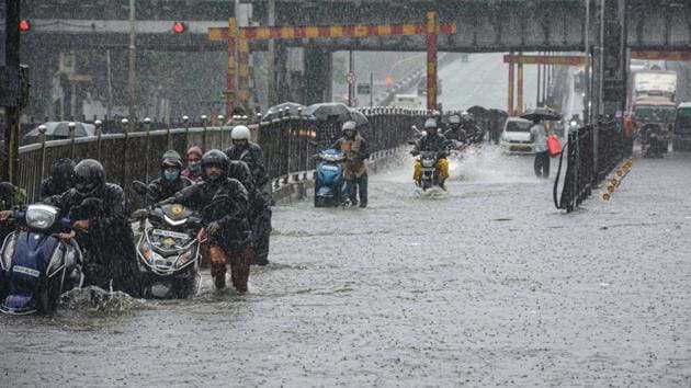 Motorists wade through a water logged street at Sion, Mumbai, on Wednesday.(PTI)