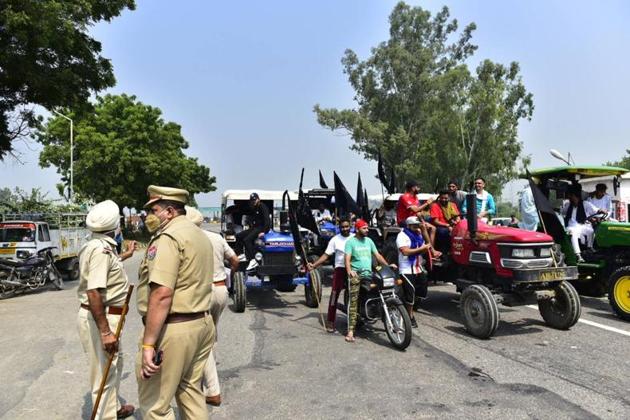 Farmers waving black flags while protesting against the three farm bills near Ladhowal Toll Plaza in Ludhiana on Friday. Security was stepped up, while passengers waited for bus services to resume after the agitation ends at 4pm. (Gurpreet Singh/HT) Farmers waving black flags while protesting against the three farm bills near Ladhowal Toll Plaza in Ludhiana on Friday. Security was stepped up, while passengers waited for bus services to resume after the agitation ends at 4pm. (Gurpreet Singh/HT)