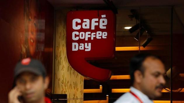 Men stand outside a Cafe Coffee Day outlet in New Delhi, India.(REUTERS) Men stand outside a Cafe Coffee Day outlet in New Delhi, India.(REUTERS)