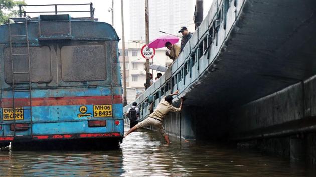 A man leaps from a bus stranded after heavy rain in Mumbai on September 23. Dr Siddarth Paliwal, a city-based private health consultant, told HT, “It is a good sign that the number of deaths has come down despite the number of cases going up drastically. This is because of early testing or detection of possible Covid-19 patients. Also, availability of drugs to stabilise several critical patients has also helped bring down the mortality rate.” (ANI) A man leaps from a bus stranded after heavy rain in Mumbai on September 23. Dr Siddarth Paliwal, a city-based private health consultant, told HT, “It is a good sign that the number of deaths has come down despite the number of cases going up drastically. This is because of early testing or detection of possible Covid-19 patients. Also, availability of drugs to stabilise several critical patients has also helped bring down the mortality rate.” (ANI)