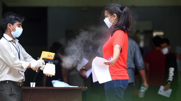 Staff sanitize a students before entering the exam center (Satish Bate/HT PHOTO) Staff sanitize a students before entering the exam center (Satish Bate/HT PHOTO)