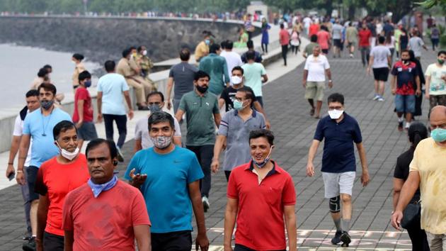 People stroll along the promenade at Marine Drive in Mumbai on September 22. Civic authorities claim the spike in the number of cases is owing to increased testing and unlocking of activities. The daily cases also started to increase owing to festivals in August. (Niharika Kulkarni / REUTERS) People stroll along the promenade at Marine Drive in Mumbai on September 22. Civic authorities claim the spike in the number of cases is owing to increased testing and unlocking of activities. The daily cases also started to increase owing to festivals in August. (Niharika Kulkarni / REUTERS)